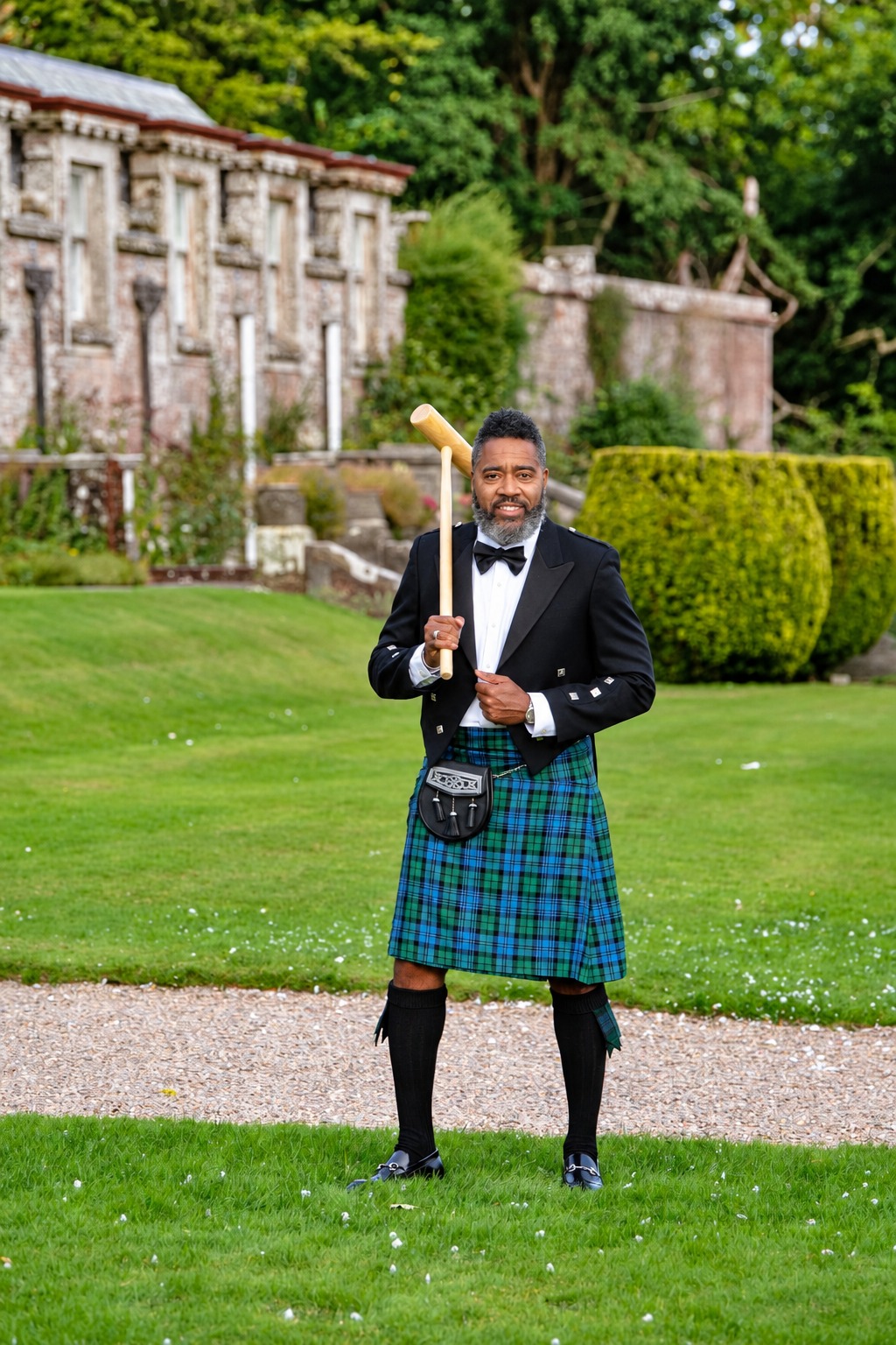 Dr. Milton Miller Jr. in formal Scottish attire on castle grounds