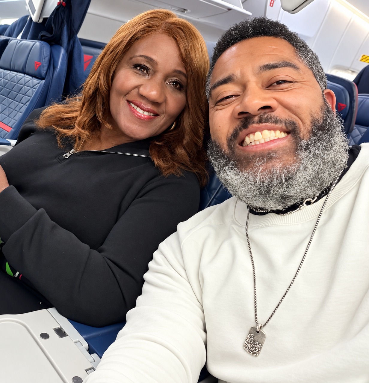 Dr. Milton Miller Jr. and a guest smiling aboard an airplane